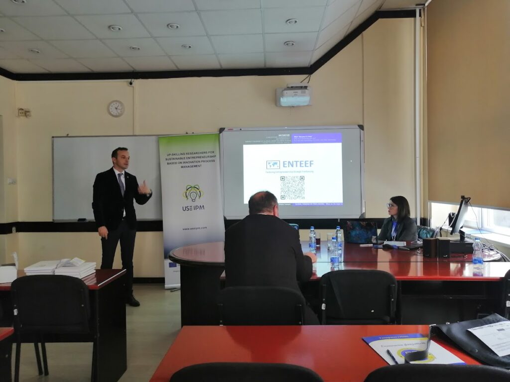 Prof. Vladan Ivanovic is standing next to the screen on which ENTEEF project logo and QR code is displayed.