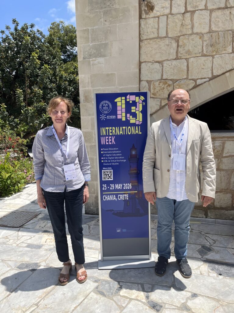 Grażyna Paliwoda-Pękosz and Dariusz Dyemk next to the poster of International Week.