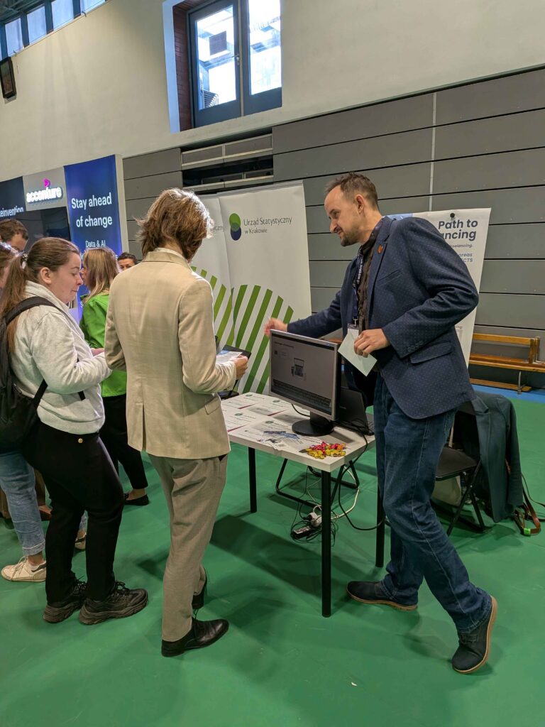 Students around ENTEEF stall. A team member explains something.