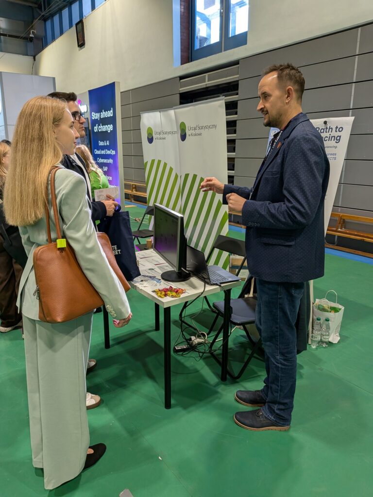 Students around ENTEEF stall. A team member explains something.
